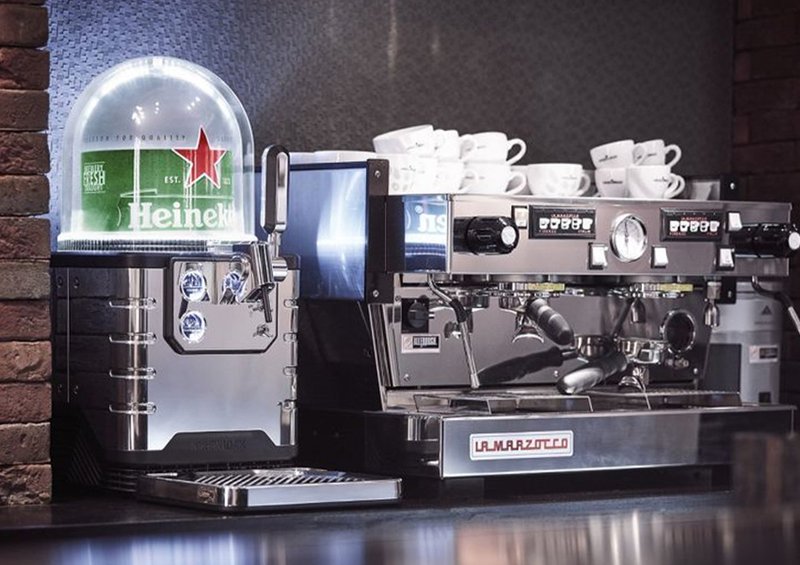 An Heineken Blade machine-result of Open Innovation- next to a coffee machine on a countertop